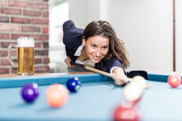 Fototapeta premium Fashionable modern woman playing pool table billiards game.