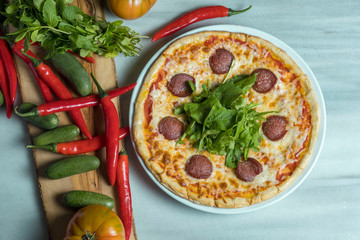 Pizza with green and red vegetables, pepper and cucumber
