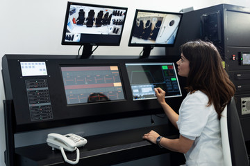 Female doctor monitoring hyperbaric oxygen therapy in control room.