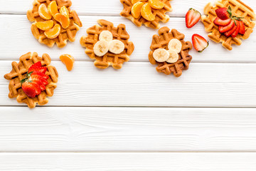 homemade Belgian waffles with fruit topings on white wooden background top view space for text