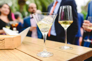 People in a cocktail drinking alcohol from their glasses and having fun at the party.