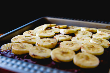Sliced banana on a cake on a tray before baking it.