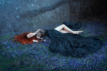 girl with red hair lying on grass in dark forest, black queen lost in battle, charming lady in long black royal dress with lace on open chest, sexy hot nymph with long bare legs in highlights of moon