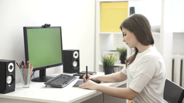 Graphic designer working on computer using tablet