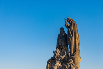 Fototapeta premium Beautiful delicate and elaborate sandstone Christian religion sculpture, Statues of Saints Cyril and Methodius, placed on the balustrade of Charles Bridge, Karlův most, in Prague, Czech Republic.