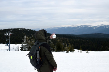 Fototapeta na wymiar Mountain traveler with crystal ball looks around in mountains