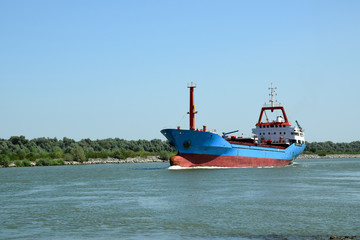 Fototapeta premium Cargo ship (bulk carrier) floats on the Danube river. Sulina, Danube Delta, Romania.