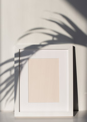 White Picture Frame with Matting on a Shelf with a Palm Tree Leaf Shadow, White Background. Poster and Print Design Photo Mock-Up, Blank and Empty Frame - 12x16 inches, 8x10 inches or Similar Ratio