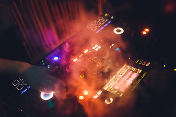 Disc Jockey DJ Entertainment with EDM Dance Music Mixer CD Player in Night Club with Lighting and Smoke Effect in Holiday.