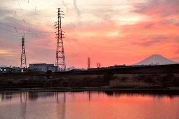 Obraz premium 夕暮れ時の相模川と赤く染まる水面と空