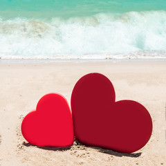 Two hearts on the sandy beach background