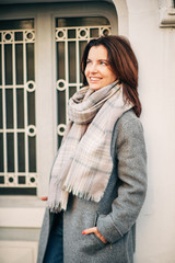 Outdoor portrait of beautiful woman wearing grey coat