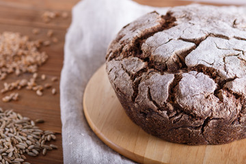 Yeast free homemade bread with whole rye and wheat grains on rustic wooden background.