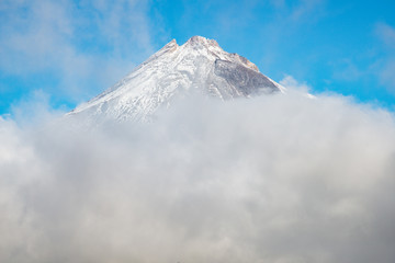 The scenery view of Mt.Taranaki (Mount Egmont) behind the clouds. This mountain is one of the popular volcano in Western region of North Island, New Plymouth, New Zealand.