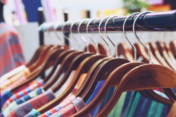 Colorful shirts hanging on rack close up