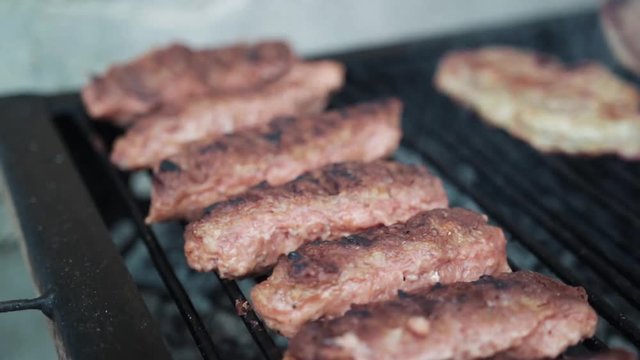 Traditional Romanian meat roles (mici) on the BBQ. Close up shot.