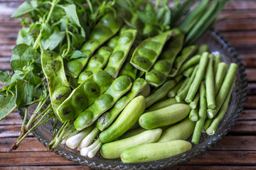 A view of the arrangement of a close-up food set,a healthy vegetable set (cucumber,sato,long-hatched bean)that is placed in a beautiful container and placed on a wooden stick to serve customers again.