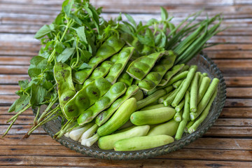 A view of the arrangement of a close-up food set,a healthy vegetable set (cucumber,sato,long-hatched bean)that is placed in a beautiful container and placed on a wooden stick to serve customers again.
