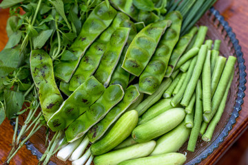 A view of the arrangement of a close-up food set,a healthy vegetable set (cucumber,sato,long-hatched bean)that is placed in a beautiful container and placed on a wooden stick to serve customers again.