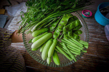 A view of the arrangement of a close-up food set,a healthy vegetable set (cucumber,sato,long-hatched bean)that is placed in a beautiful container and placed on a wooden stick to serve customers again.