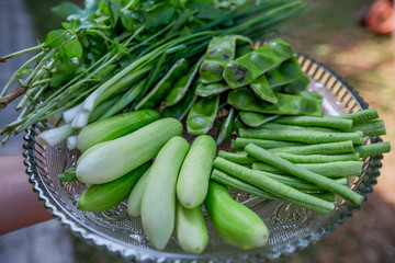A view of the arrangement of a close-up food set,a healthy vegetable set (cucumber,sato,long-hatched bean)that is placed in a beautiful container and placed on a wooden stick to serve customers again.