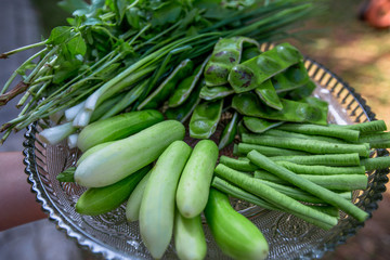 A view of the arrangement of a close-up food set,a healthy vegetable set (cucumber,sato,long-hatched bean)that is placed in a beautiful container and placed on a wooden stick to serve customers again.