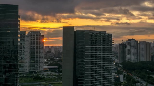 Sunset time lapse during twilight in urban landscape with cars moving on avenue and among buildings in S&atilde;o Paulo City Brasil