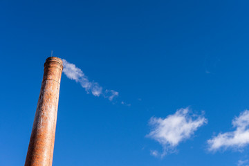 smoke from chimney on background of blue sky