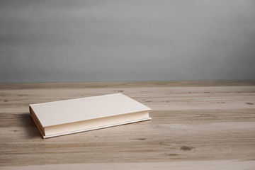 One book on a table or desk.  テーブルの上に置かれた一冊の本