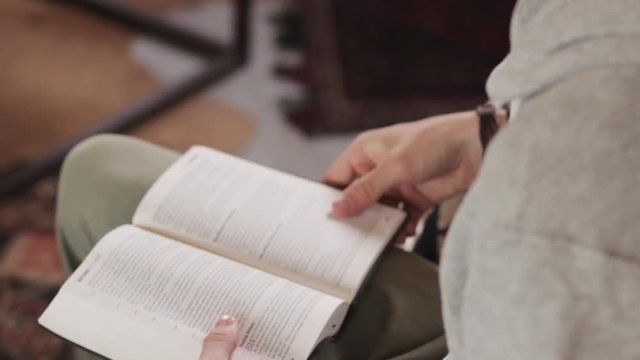 A young man is reading his Bible on a couch