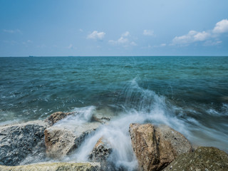 Ocean water rushing by a rock.