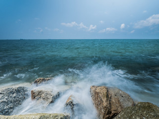 Ocean water rushing by a rock.