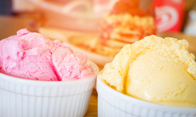 ice cream cup on wooden tray / Yellow vanilla and strawberry ice cream scoop on the table background top view