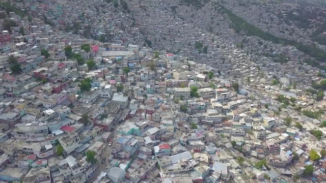 Amazing aerial over the slums, favela and shanty towns in the Cite Soleil district of Port Au Prince, Haiti with soccer stadium foreground.