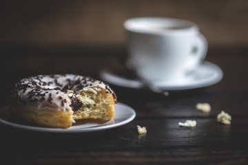 Bite a white donut with chocolate sprinkle