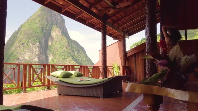 A sexy woman walks out onto a balcony of a hotel or resort on the Caribbean Island of St. Lucia.