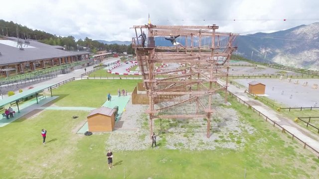 Nice aerial of a man ziplining on a zipline from a tall tower in Andorra, Europe.