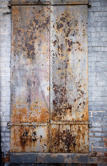 Metal painted doors rusting w/brick