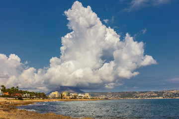 An extremely large and very high cloud over a mountain behind the Spanish coastal town of Javea...