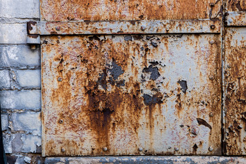 Metal rusted door + hinge + brick