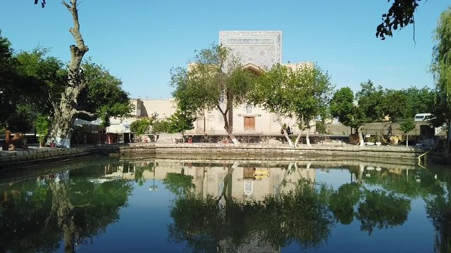 Lyab-i Hauz reflecting in the pond. In Bukhara, Uzbekistan.