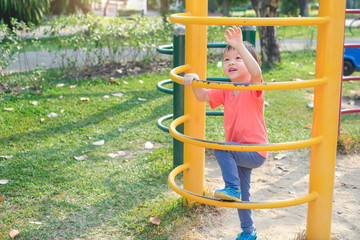 Obraz premium Cute little Asian 3 years old toddler baby boy child having fun trying to climb on climbing frame at outdoor playground, Physical, Hand and Eye Coordination, Sensory, Motor Skills development concept