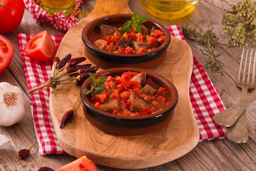 Marinated pork loin in tomato sauce.
