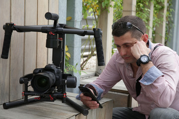 Videographer with gimball video dslr, Professional video. Videographer at the event sets up the camera