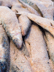 Close up of raw breaded with bread crumbs fishes