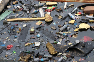 Trash and garbage floating on the surface of the water, causing sewage.