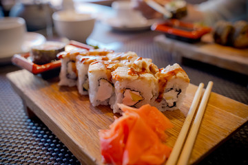 Traditional Asian food sushi on wooden plate.