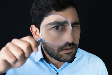Businessman with magnifying glass, tax inspector doing financial auditing, retro toned, selective focus
