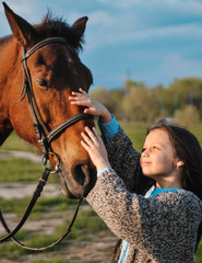 Obraz premium Beautiful girl with horse on the grass. Friendship concept.