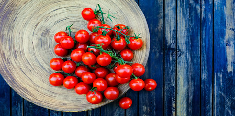 Trusses of tomatoes on the rustic wood bowl.  Full of   lycopene Cherry tomatoes background and...